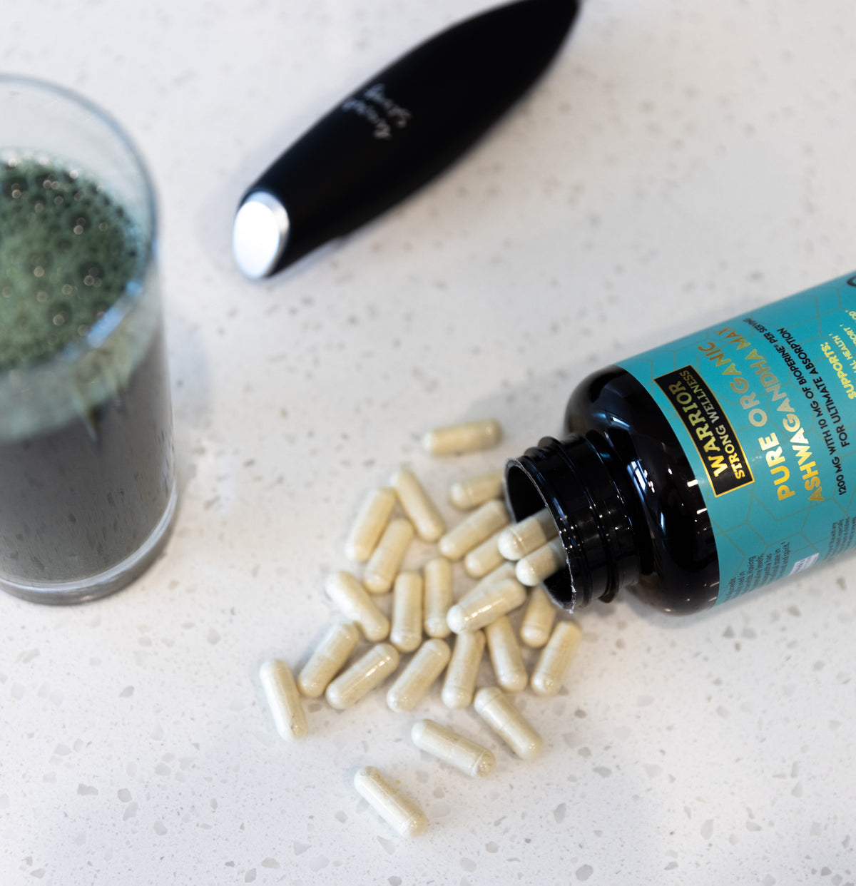 Ashwagandha supplement bottle on counter with capsules pouring out of bottle.
