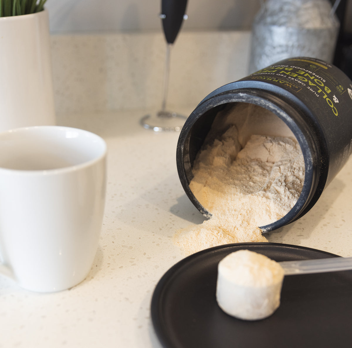 Warrior Strong Wellness Collagen Peptides & Bone Broth Protein with measuring scoop, coffee mug, and frother, demonstrating easy mixing into hot drinks.