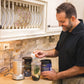 Person making a healthy smoothie with Warrior Strong Wellness collagen supplements, fresh spinach, and fruit in a blender for daily nutrition and wellness support.