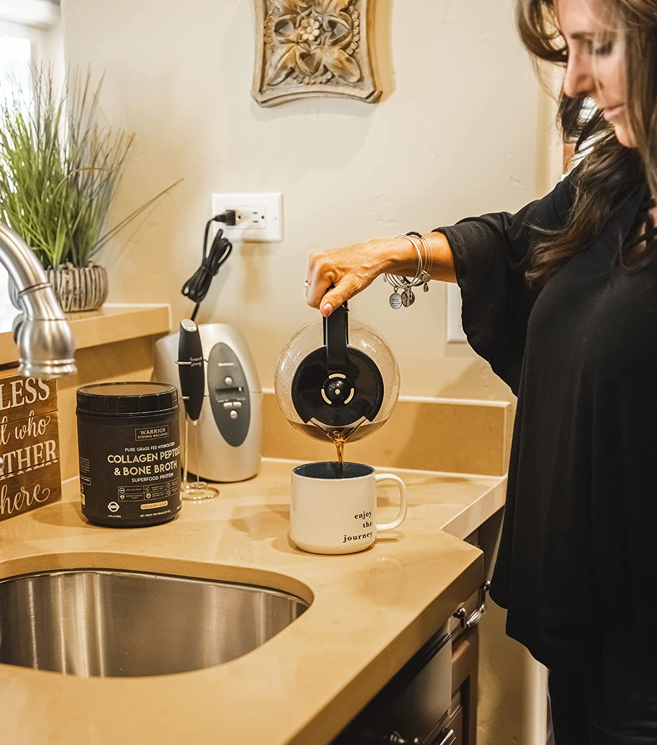 Woman preparing coffee with Warrior Strong Wellness Collagen Peptides & Bone Broth, showcasing an easy way to add collagen protein to a daily morning routine.